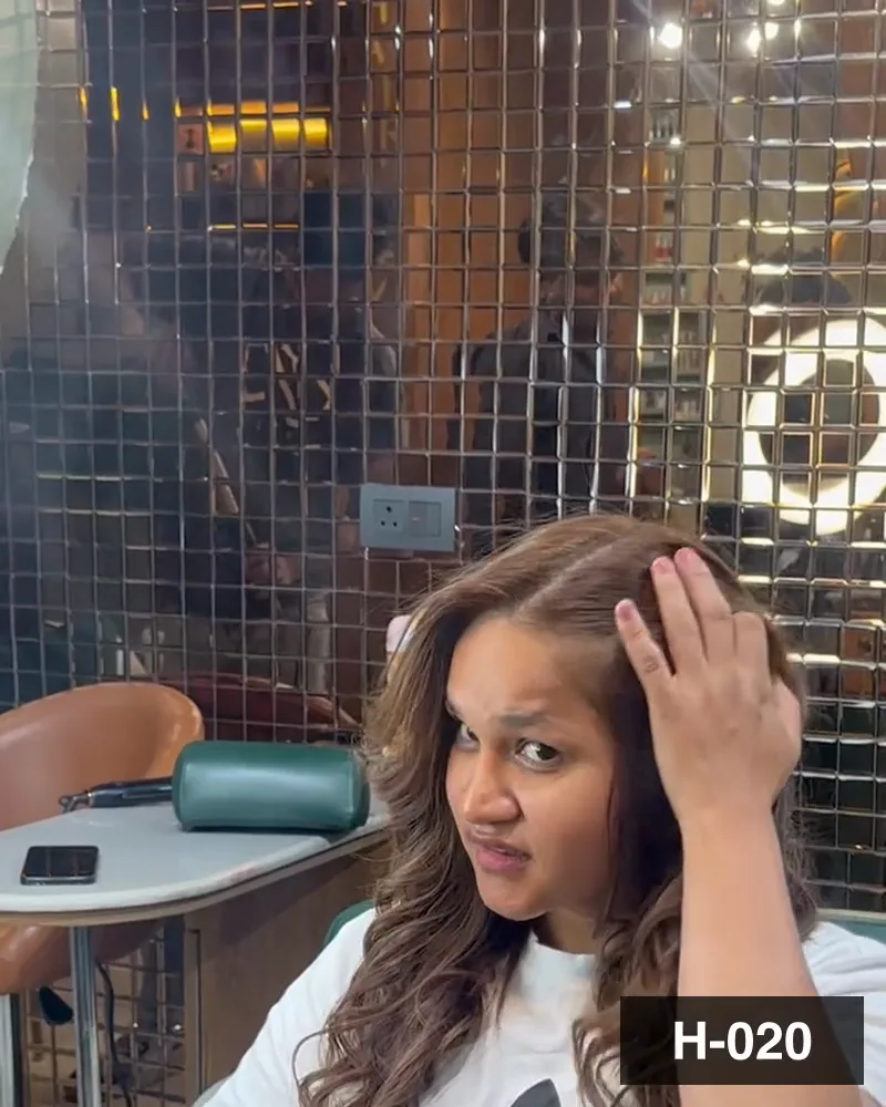 A guest with curled hair at the mirror, facing the camera at Salon By Babita, Haldwani — reference H-020