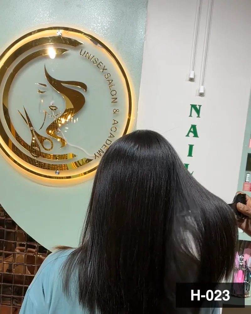 Long dark hair combed straight beside the salon signage, seen from behind at Salon By Babita, Haldwani — reference H-023