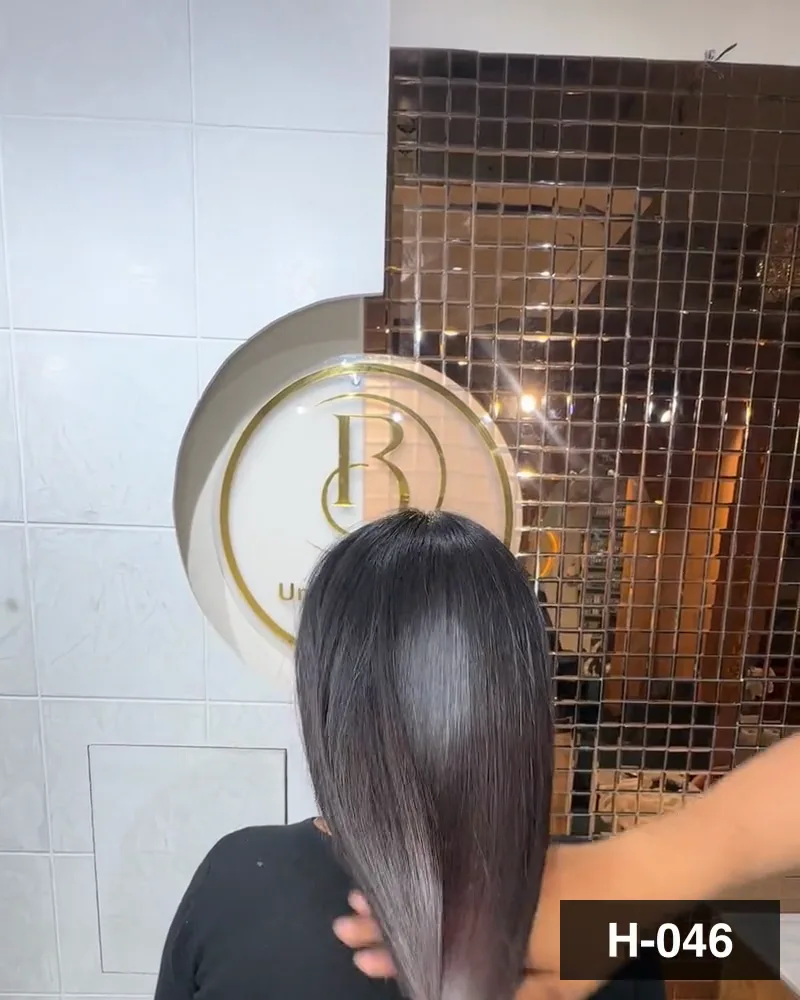 Long dark hair smoothed with a brush under the salon monogram, seen from behind at Salon By Babita, Haldwani — reference H-046