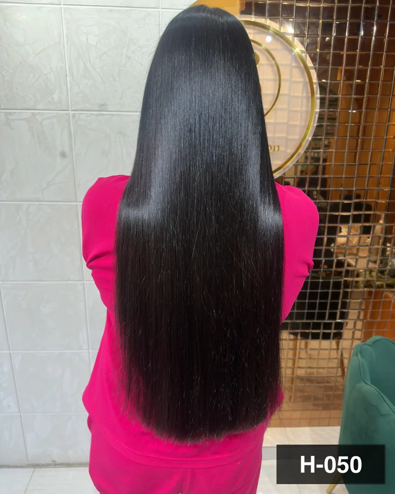 Waist-length black hair combed straight to a mirror finish, seen from behind under the salon monogram at Salon By Babita, Haldwani — reference H-050