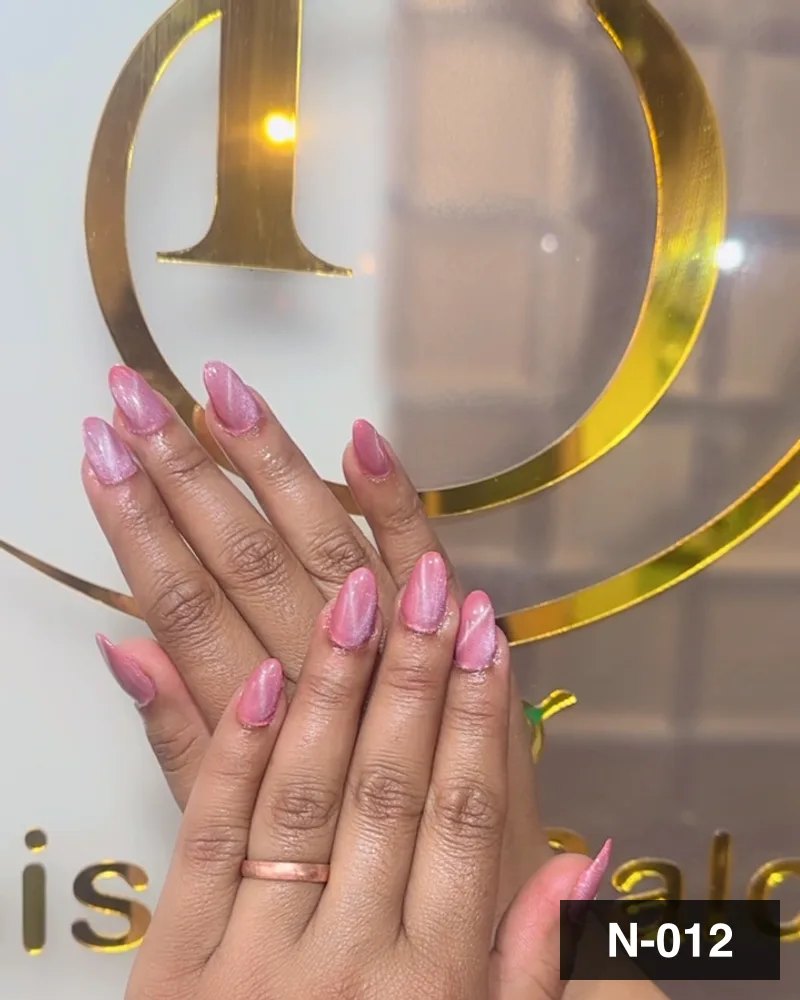 A soft pink ombré long almond set, both hands laid flat against the salon's gold monogram at Salon By Babita, Haldwani — reference N-012