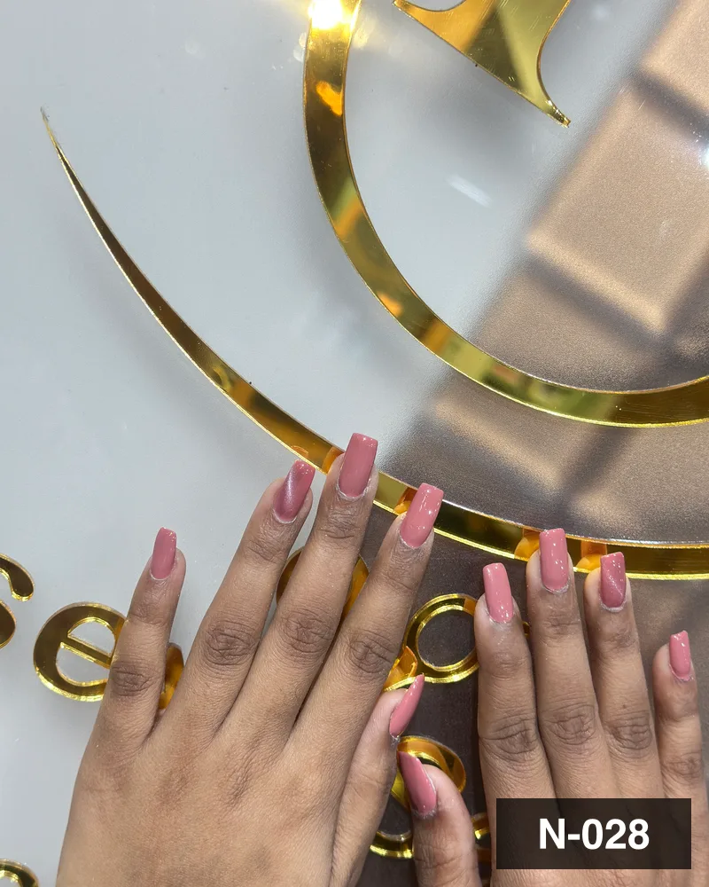 A rose ombré long almond set, photographed against the salon's gold monogram at Salon By Babita, Haldwani — reference N-028