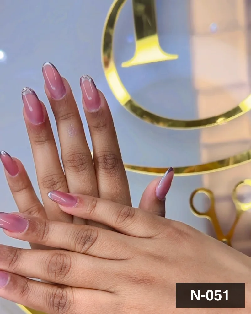 A rose ombré long almond set, photographed against the salon's gold monogram at Salon By Babita, Haldwani — reference N-051