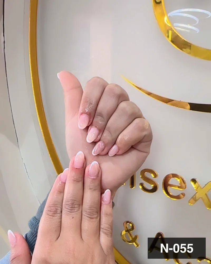 A pale pink almond set, both hands raised against the salon's gold monogram at Salon By Babita, Haldwani — reference N-055