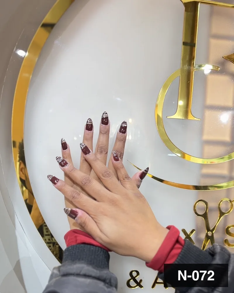 A wine set with silver glitter detail, one hand against the salon's gold monogram at Salon By Babita, Haldwani — reference N-072