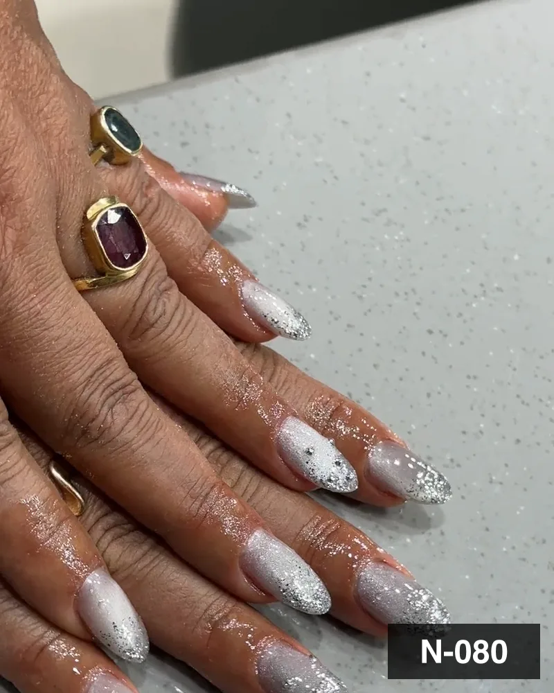 A silver glitter french almond set, one hand on the salon counter at Salon By Babita, Haldwani — reference N-080