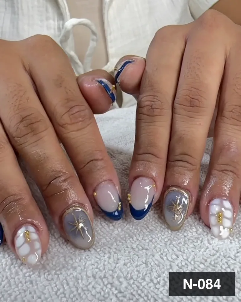 A navy french nail set with grey marble starbursts, raised white florals and gold charms on both hands at Salon By Babita, Haldwani — reference N-084