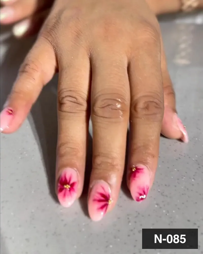 A soft pink almond nail set airbrushed with a deep magenta flower on each nail at Salon By Babita, Haldwani — reference N-085