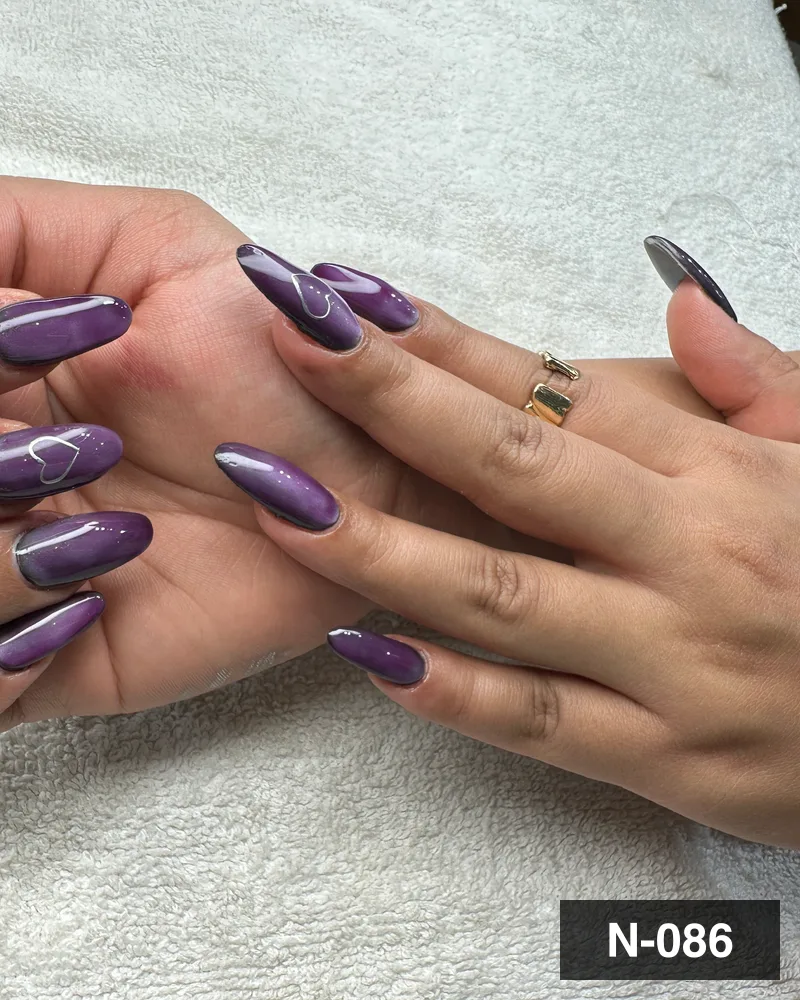 A purple cat-eye long almond nail set with freehand white detail on both hands at Salon By Babita, Haldwani — reference N-086