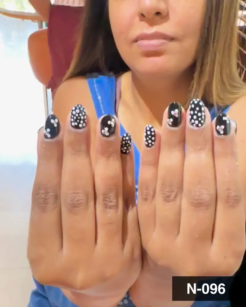 A black nail set with white dots and raised white flowers on both hands at Salon By Babita, Haldwani — reference N-096