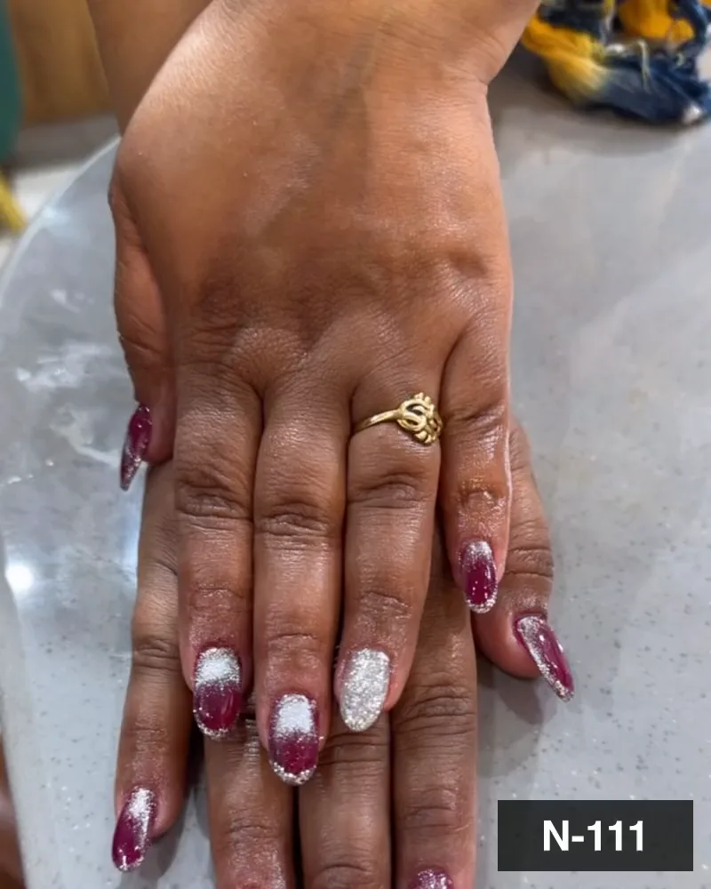 A wine red nail set with white glitter french tips on both hands on a marble surface at Salon By Babita, Haldwani — reference N-111
