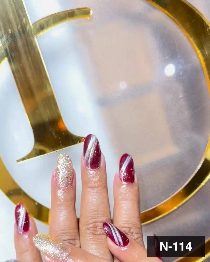 A deep wine cat-eye nail set with gold glitter accent nails on both hands at Salon By Babita, Haldwani — reference N-114