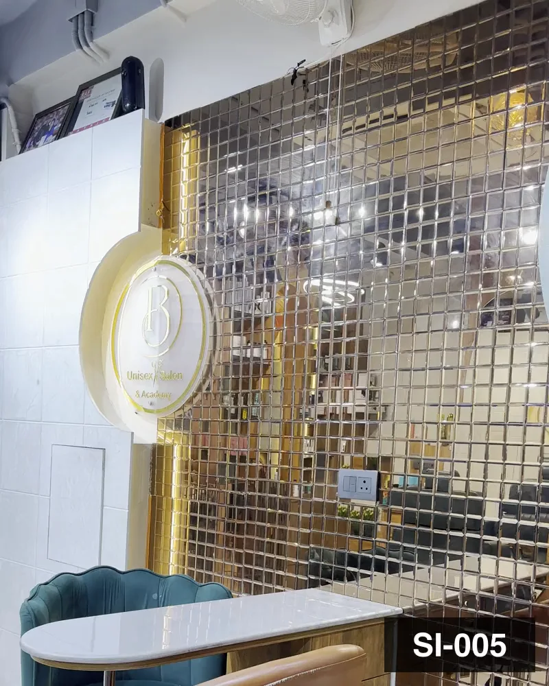The gold mosaic mirror wall behind the consultation table at Salon By Babita, Haldwani — reference SI-005