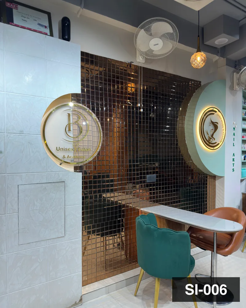 The etched brass brand disc above the nail counter at Salon By Babita, Haldwani — reference SI-006