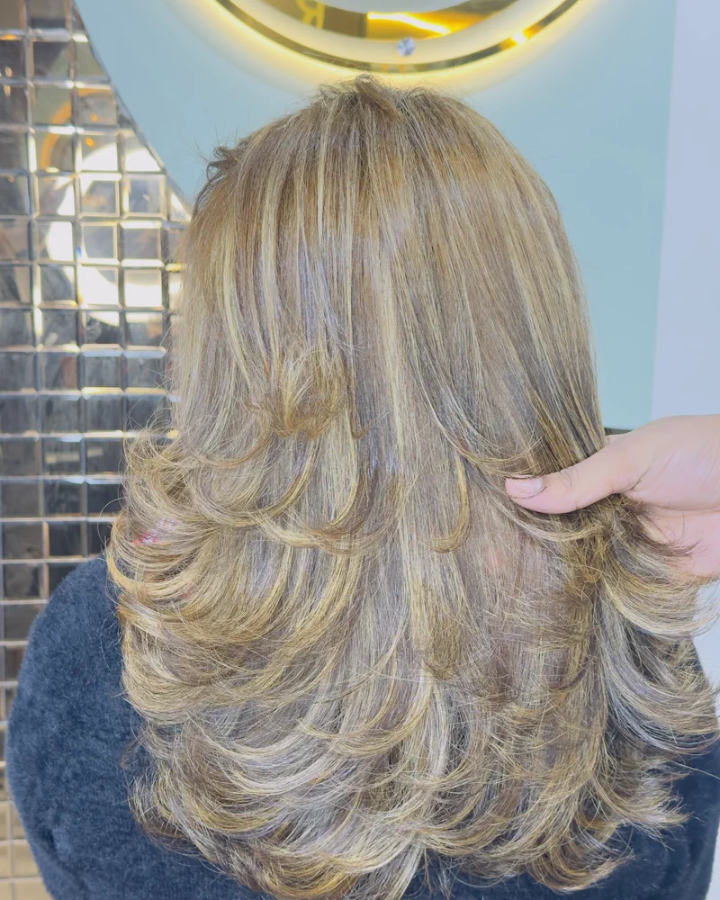 Blonde highlights through layered mid-length hair, seen from behind at Salon By Babita, Haldwani