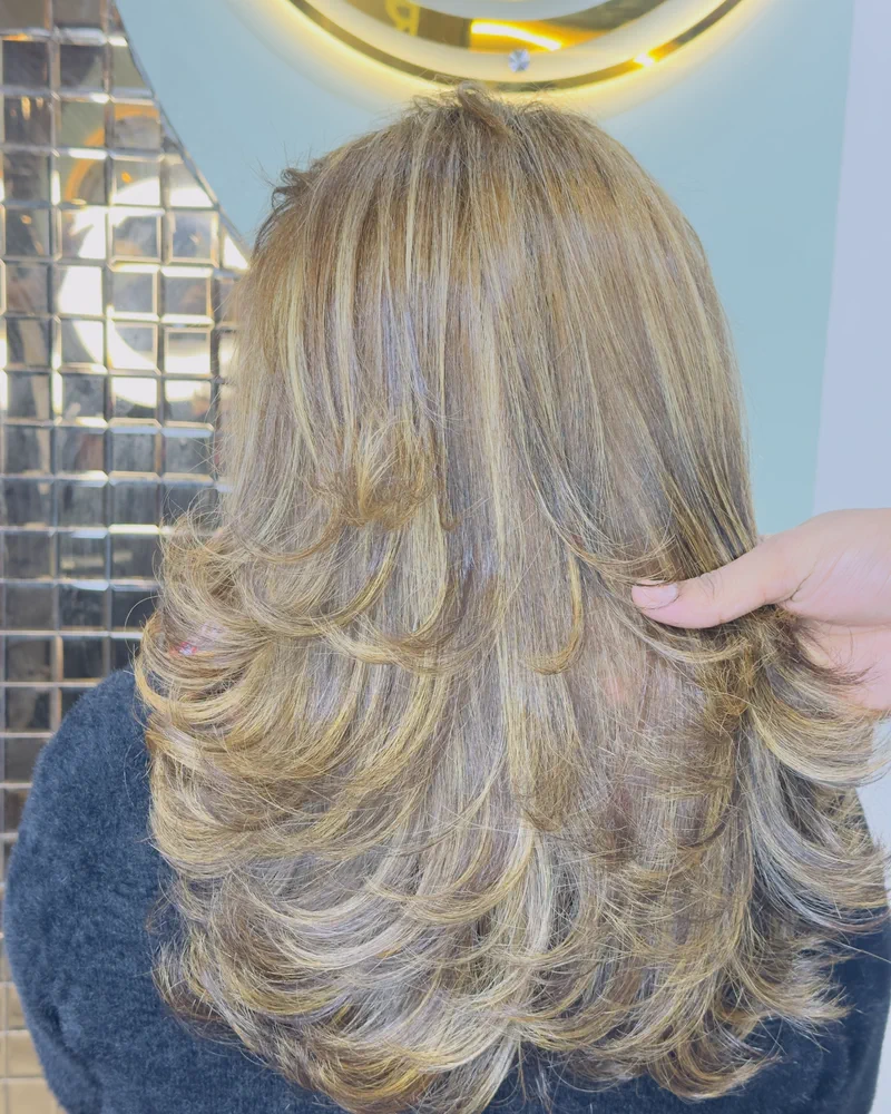 Layered hair lightened to blonde and blow-dried out at the ends, seen from behind at Salon By Babita, Haldwani