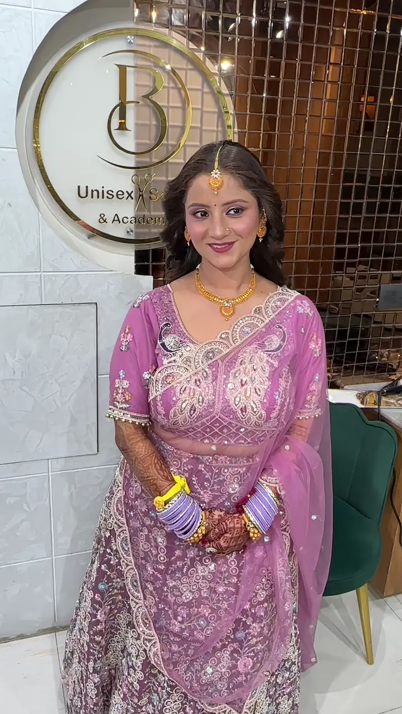 Bride in a pink embroidered lehenga with gold jewellery, maang tikka and chooda, styled at Salon By Babita, Haldwani