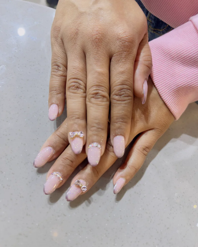 A pale pink almond nail set with crystal detail at Salon By Babita, Haldwani