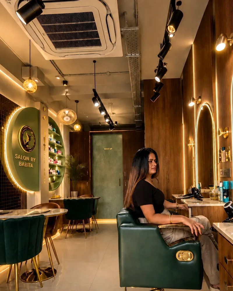 The Salon By Babita interior in Haldwani, a guest seated at a styling station beside the backlit salon sign